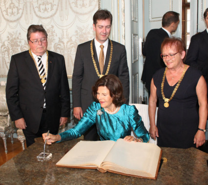 Königlicher Besuch in Würzburg: Bürgermeister Adolf Bauer, Oberbürgermeister Christian Schuchardt und Bürgermeisterin Marion Schäfer-Blake verfolgen den Eintrag der schwedischen Monarchin Silvia in das Goldene Buch der Stadt. (Foto: Georg Wagenbrenner)