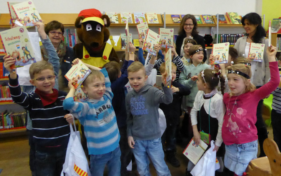 Die Erstklässler der Grundschule Stadtmitte freuen sich mit ihrer Klassenlehrerin Brigitte Geier (rechts), Susanne Baumann (Arena Verlag, Mitte) und Angelika Riedel (Stadtbücherei, links) über die Geschenke des Bücherbären. (Foto: Stadt Würzburg)